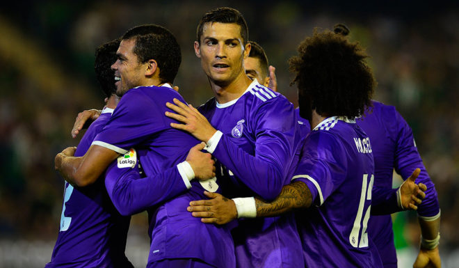 Real Madrid's Portuguese forward Cristiano Ronaldo (C) and Real Madrid's Portuguese defender Pepe (L) congratulates Real Madrid's midfielder Isco (hidden) after he scored during the Spanish league football match Real Betis vs Real Madrid CF at the Benito Villamarin stadium in Sevilla on October 15, 2016. / AFP / CRISTINA QUICLER (Photo credit should read CRISTINA QUICLER/AFP/Getty Images)