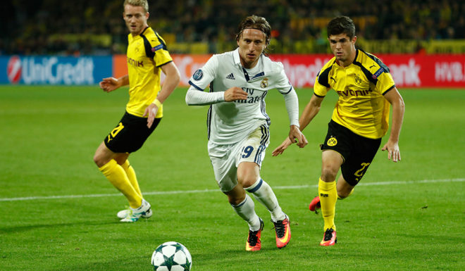 Real Madrid's Croatian midfielder Luka Modric (c) and Dortmund's US midfielder Christian Pulisic (R) and Dortmund's midfielder Andre Schuerrle vie during the UEFA Champions League first leg football match between Borussia Dortmund and Real Madrid at BVB stadium in Dortmund, on September 27, 2016. / AFP / Odd ANDERSEN (Photo credit should read ODD ANDERSEN/AFP/Getty Images)