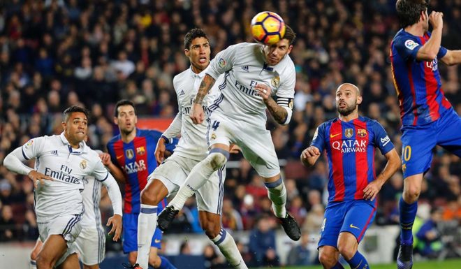 TOPSHOT - Real Madrid's defender Sergio Ramos (C) heads a ball to score the equalizer past Real Madrid's French defender Raphael Varane (3rdL) and Barcelona's Argentinian defender Javier Mascherano (R) during the Spanish league football match FC Barcelona vs Real Madrid CF at the Camp Nou stadium in Barcelona on December 3, 2016. / AFP / PAU BARRENA (Photo credit should read PAU BARRENA/AFP/Getty Images)