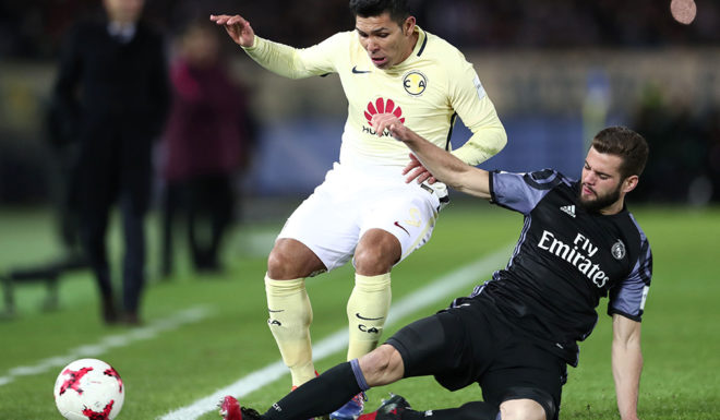 Real Madrid's defender Nacho Fernandez (R) fights for the ball with Club America's forward Silvio Romero (L) during the Club World Cup semi-final football match between Club America of Mexico and Real Madrid of Spain at Yokohama International stadium in Yokohama on December 15, 2016. / AFP / Behrouz MEHRI (Photo credit should read BEHROUZ MEHRI/AFP/Getty Images)