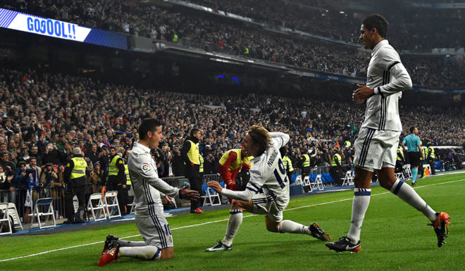 Real Madrid's Colombian midfielder James Rodriguez (L) celebrates with Real Madrid's Croatian midfielder Luka Modric (C) and Real Madrid's French defender Raphael Varane after scoring on a penalty kick during the Spanish Copa del Rey (King's Cup) round of 16 first leg football match Real Madrid CF vs Sevilla FC at the Santiago Bernabeu stadium in Madrid on January 4, 2017. / AFP / GERARD JULIEN (Photo credit should read GERARD JULIEN/AFP/Getty Images)