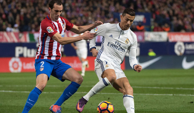 TOPSHOT - Atletico Madrid's Uruguayan defender Diego Godin (L) vies with Real Madrid's Portuguese forward Cristiano Ronaldo during the Spanish league football match Club Atletico de Madrid vs Real Madrid CF at the Vicente Calderon stadium in Madrid, on November 19, 2016. / AFP / CURTO DE LA TORRE (Photo credit should read CURTO DE LA TORRE/AFP/Getty Images)