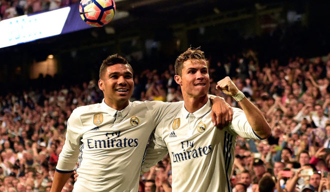 Real Madrid's Portuguese forward Cristiano Ronaldo (R) celebrates a goal with Real Madrid's Brazilian midfielder Casemiro during the Spanish league football match Real Madrid CF vs Sevilla FC at the Santiago Bernabeu stadium in Madrid on May 14, 2017. / AFP PHOTO / GERARD JULIEN (Photo credit should read GERARD JULIEN/AFP/Getty Images)