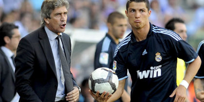 Real Madrid's Portuguese forward Cristiano Ronaldo (R) holds a ball as he stands next to Real Madrid's coach Manuel Pellegrini (L) during a football match against Malaga at La Rosaleda's stadium in Malaga, on May 16, 2010.AFP PHOTO / CRISTINA QUICLER (Photo credit should read CRISTINA QUICLER/AFP/Getty Images)