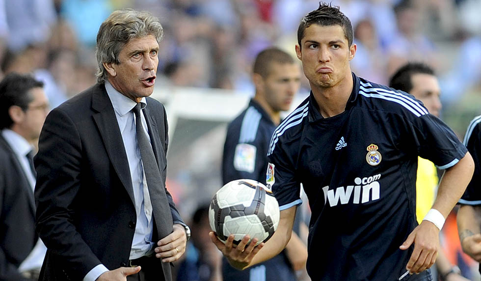 Real Madrid's Portuguese forward Cristiano Ronaldo (R) holds a ball as he stands next to Real Madrid's coach Manuel Pellegrini (L) during a football match against Malaga at La Rosaleda's stadium in Malaga, on May 16, 2010.AFP PHOTO / CRISTINA QUICLER (Photo credit should read CRISTINA QUICLER/AFP/Getty Images)