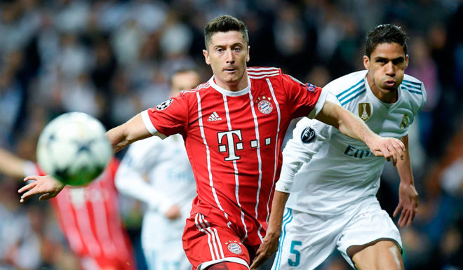 Bayern Munich's Polish forward Robert Lewandowski (L) challenges Real Madrid's French defender Raphael Varane during the UEFA Champions League semi-final second leg football match between Real Madrid and Bayern Munich at the Santiago Bernabeu Stadium in Madrid on May 1, 2018. (Photo by OSCAR DEL POZO / AFP) (Photo credit should read OSCAR DEL POZO/AFP/Getty Images)