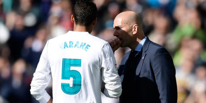 Real Madrid's French coach Zinedine Zidane (R) talks with Real Madrid's French defender Raphael Varane during the Spanish league football match between Real Madrid CF and Club Atletico de Madrid at the Santiago Bernabeu stadium in Madrid on April 8, 2018. / AFP PHOTO / JAVIER SORIANO (Photo credit should read