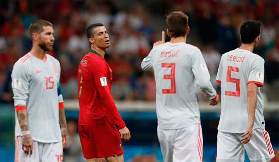 Spain's defender Gerard Pique (2R) gestures at Portugal's forward Cristiano Ronaldo (2L) during the Russia 2018 World Cup Group B football match between Portugal and Spain at the Fisht Stadium in Sochi on June 15, 2018. (Photo by Adrian DENNIS / AFP) / RESTRICTED TO EDITORIAL USE - NO MOBILE PUSH ALERTS/DOWNLOADS (Photo credit should read ADRIAN DENNIS/AFP/Getty Images)