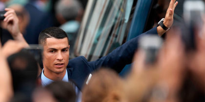 Real Madrid's Portuguese forward Cristiano Ronaldo greets supporters at the Puerta del Sol square in Madrid on May 27, 2018 as players celebrate their third Champions League title in a row in Kiev. (Photo by OSCAR DEL POZO / AFP) (Photo credit should read OSCAR DEL POZO/AFP/Getty Images)