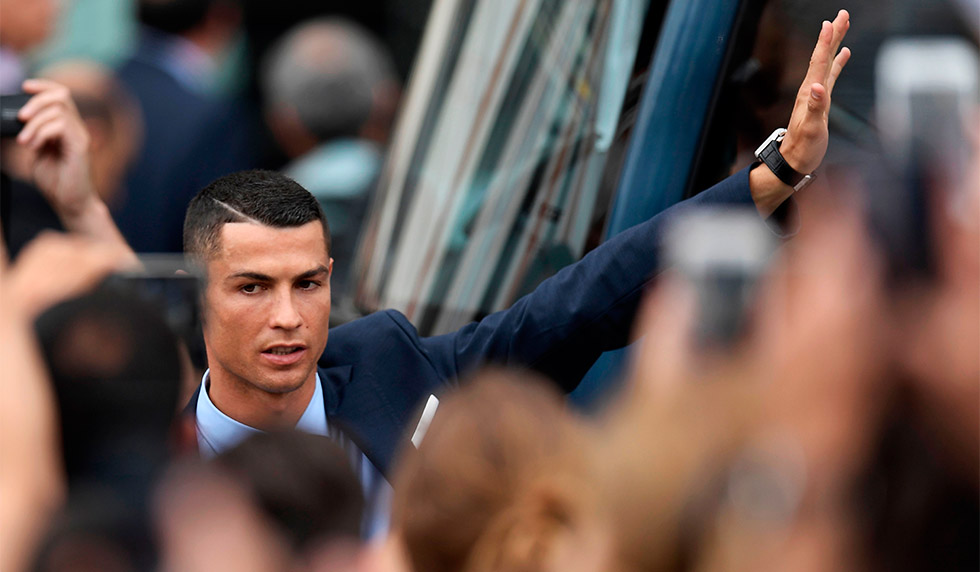 Real Madrid's Portuguese forward Cristiano Ronaldo greets supporters at the Puerta del Sol square in Madrid on May 27, 2018 as players celebrate their third Champions League title in a row in Kiev. (Photo by OSCAR DEL POZO / AFP) (Photo credit should read OSCAR DEL POZO/AFP/Getty Images)