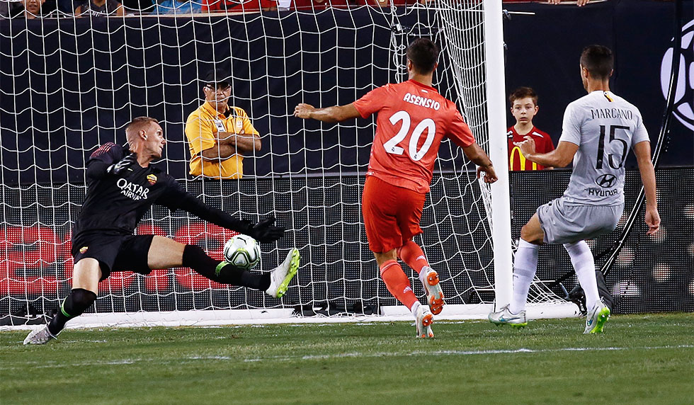 EAST RUTHERFORD, NJ - AUGUST 7: Marco Asensio #20 of Real Madrid scores on Robin Olsen #1 of Roma during their match at MetLife Stadium on August 7, 2018 in East Rutherford, New Jersey. (Photo by Jeff Zelevansky/Getty Images)