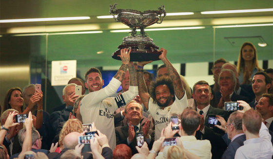 MADRID, SPAIN - AUGUST 11: Captain of Real Madrid Sergio Ramos (L) and his teammate Marcelo (R) stand the Santiago Bernabéu Trophy ahead their president Florentino Perez (2ndL) after winning the friendly match between Real Madrid CF and AC Milan at Estadio Santiago Bernabeu on August 11, 2018 in Madrid, Spain. (Photo by Gonzalo Arroyo Moreno/Getty Images)