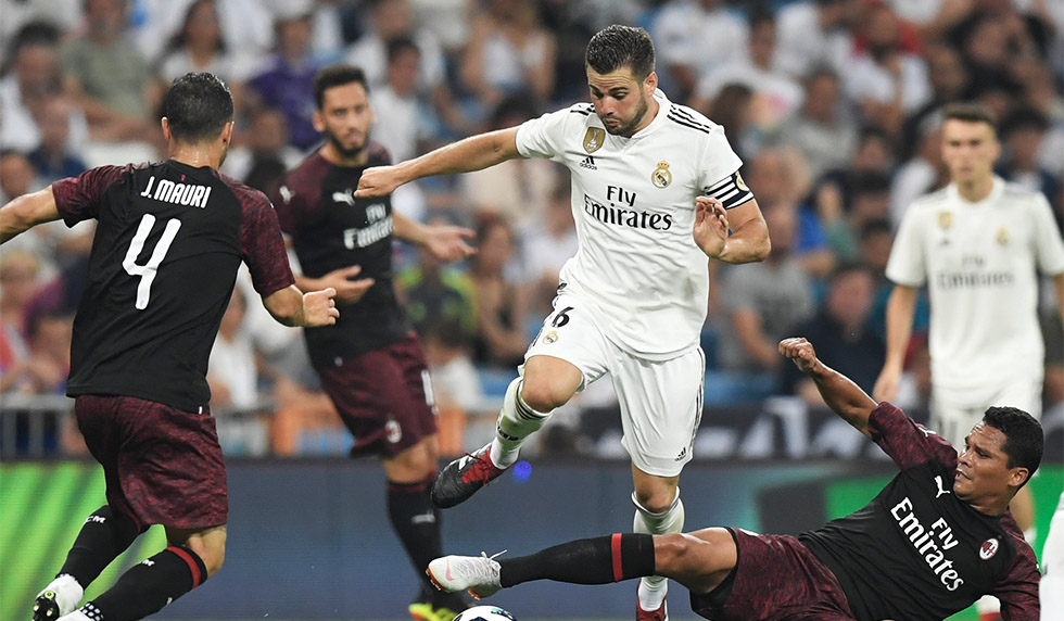 Real Madrid's Spanish defender Nacho Fernandez (C) challenges AC Milan's Colombian forward Carlos Bacca (R) during the Santiago Bernabeu Trophy football match between Real Madrid and AC Milan in Madrid on August 11, 2018. (Photo by GABRIEL BOUYS / AFP) (Photo credit should read GABRIEL BOUYS/AFP/Getty Images)
