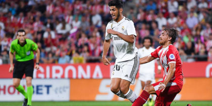 GIRONA, SPAIN - AUGUST 26: Marco Asensio of Real Madrid CF is brought down by Marc Muniesa of Girona FC during the La Liga match between Girona FC and Real Madrid CF at Montilivi Stadium on August 26, 2018 in Girona, Spain. (Photo by David Ramos/Getty Images)