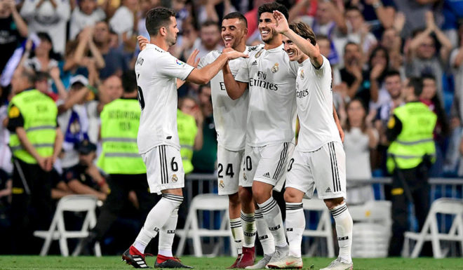 Real Madrid's Spanish midfielder Marco Asensio (C) celebrates with teammtes after scoring during the Spanish league football match between Real Madrid CF and RCD Espanyol at the Santiago Bernabeu stadium in Madrid on September 22, 2018. (Photo by JAVIER SORIANO / AFP) (Photo credit should read JAVIER SORIANO/AFP/Getty Images)