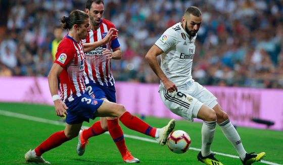 MADRID, SPAIN - SEPTEMBER 29: Karim Benzema (R) of Real Madrid CF competes for the ball with Filipe Luis (L) of Atletico de Madrid and his teammate Diego Godin (2ndL) during the La Liga match between Real Madrid CF and Club Atletico de Madrid at Estadio Santiago Bernabeu on September 29, 2018 in Madrid, Spain. (Photo by Gonzalo Arroyo Moreno/Getty Images)