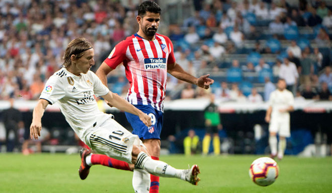 Real Madrid's Croatian midfielder Luka Modric (L) vies with Atletico Madrid's Spanish forward Diego Costa during the Spanish league football match between Real Madrid CF and Club Atletico de Madrid at the Santiago Bernabeu stadium in Madrid on September 29, 2018. (Photo by CURTO DE LA TORRE / AFP) (Photo credit should read CURTO DE LA TORRE/AFP/Getty Images)