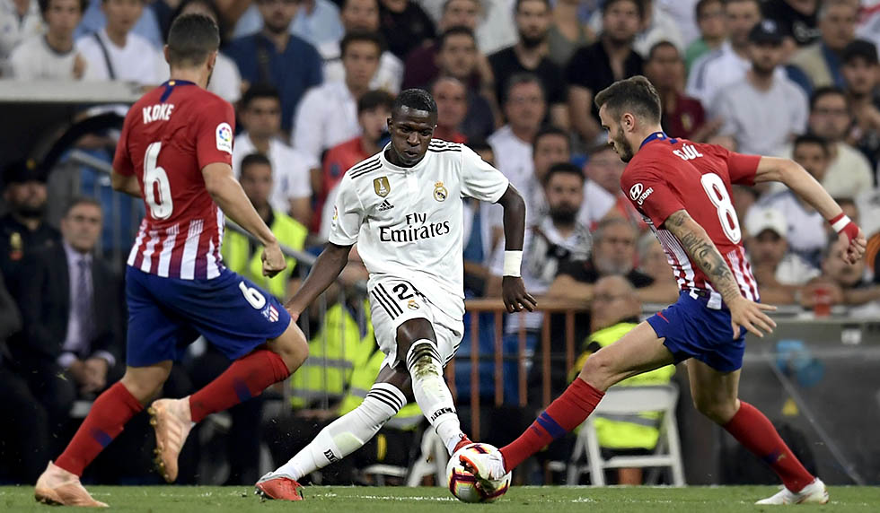 Real Madrid's Brazilian forward Vinicius Juniorv (C) vies with Atletico Madrid's Spanish midfielder Koke (L) and Atletico Madrid's Spanish midfielder Saul Niguez during the Spanish league football match between Real Madrid CF and Club Atletico de Madrid at the Santiago Bernabeu stadium in Madrid on September 29, 2018. (Photo by OSCAR DEL POZO / AFP) (Photo credit should read OSCAR DEL POZO/AFP/Getty Images)