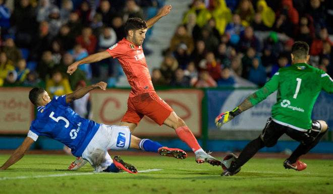 Real Madrid's Spanish midfielder Marco Asensio (C) vies with UD Melilla's Spanish defender Mohamed Mahanan (L) and Spanish goalkeeper Dani Barrio during the Spanish King's Cup football match between UD Melilla and Real Madrid CF at the Alvarez Claro municipal stadium in the autonomous city of Melilla on October 31, 2018. (Photo by JORGE GUERRERO / AFP) (Photo credit should read JORGE GUERRERO/AFP/Getty Images)