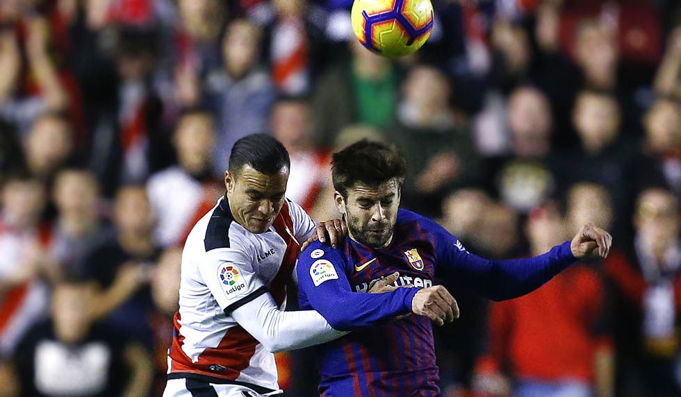 Barcelona's Spanish defender Gerard Pique (R) heads the ball with Rayo Vallecano's Spanish forward Raul de Tomas during the Spanish league football match between Rayo Vallecano de Madrid and FC Barcelona at the Vallecas stadium in Madrid on November 3, 2018. (Photo by BENJAMIN CREMEL / AFP) (Photo credit should read BENJAMIN CREMEL/AFP/Getty Images)