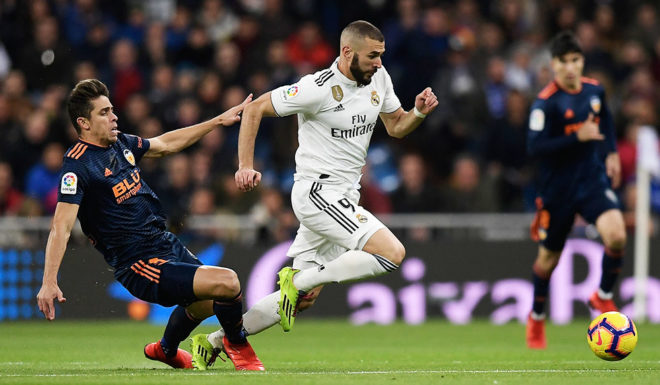 Real Madrid's French forward Karim Benzema challenges Valencia's Brazilian defender Gabriel Paulista (L) during the Spanish league football match between Real Madrid and Valencia at the Santiago Bernabeu stadium in Madrid on December 1, 2018. (Photo by OSCAR DEL POZO / AFP) (Photo credit should read OSCAR DEL POZO/AFP/Getty Images)