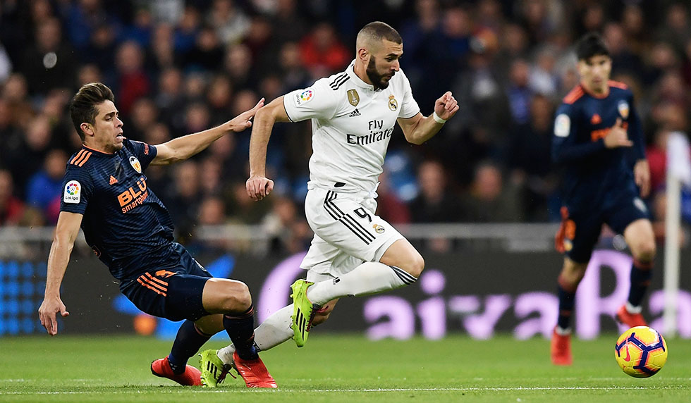 Real Madrid's French forward Karim Benzema challenges Valencia's Brazilian defender Gabriel Paulista (L) during the Spanish league football match between Real Madrid and Valencia at the Santiago Bernabeu stadium in Madrid on December 1, 2018. (Photo by OSCAR DEL POZO / AFP) (Photo credit should read OSCAR DEL POZO/AFP/Getty Images)