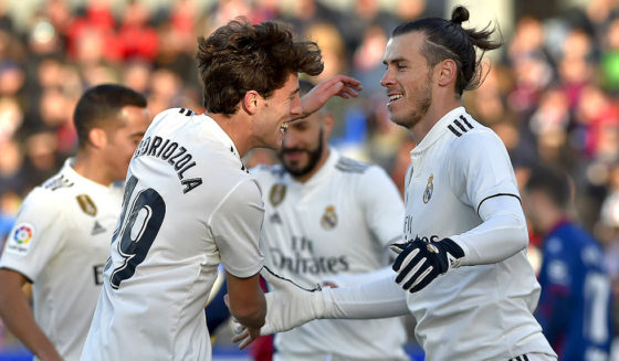 Real Madrid's Welsh forward Gareth Bale (R) is congratulated by teammate defender Alvaro Odriozola after scoring his team's first goal during the Spanish league football match between SD Huesca and Real Madrid CF at the El Alcoraz stadium on December 9, 2018. (Photo by ANDER GILLENEA / AFP) (Photo credit should read ANDER GILLENEA/AFP/Getty Images)