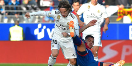 Real Madrid's Croatian midfielder Luka Modric (L) vies with Huesca's Colombian forward Juan Camilo Hernandez during the Spanish league football match between SD Huesca and Real Madrid CF at the El Alcoraz stadium on December 9, 2018. (Photo by ANDER GILLENEA / AFP) (Photo credit should read ANDER GILLENEA/AFP/Getty Images)