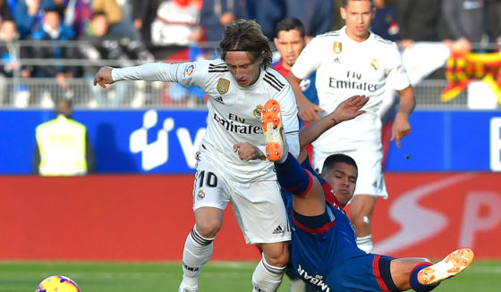 Real Madrid's Croatian midfielder Luka Modric (L) vies with Huesca's Colombian forward Juan Camilo Hernandez during the Spanish league football match between SD Huesca and Real Madrid CF at the El Alcoraz stadium on December 9, 2018. (Photo by ANDER GILLENEA / AFP) (Photo credit should read ANDER GILLENEA/AFP/Getty Images)
