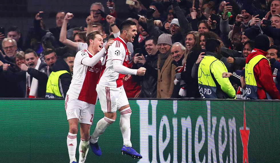 AMSTERDAM, NETHERLANDS - DECEMBER 12: Dusan Tadic of Ajax celebrates with team mates after scoring his sides second goal during the UEFA Champions League Group E match between Ajax and FC Bayern Muenchen at Johan Cruyff Arena on December 12, 2018 in Amsterdam, Netherlands. (Photo by Dean Mouhtaropoulos/Getty Images)