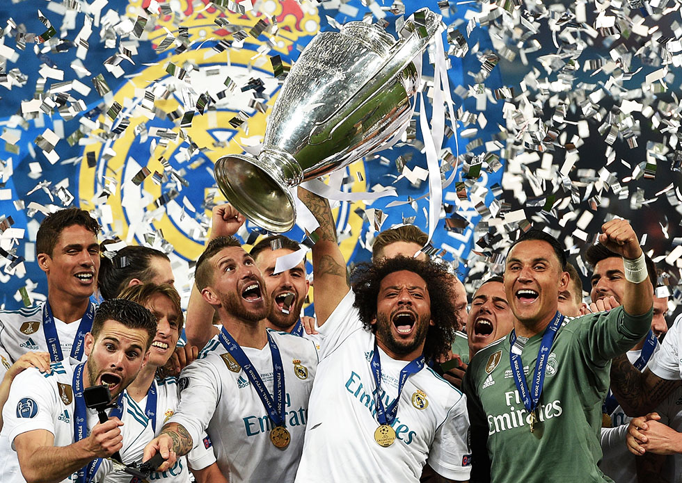 TOPSHOT - Real Madrid's Brazilian defender Marcelo (C) lifts the trophy after winning the UEFA Champions League final football match between Liverpool and Real Madrid at the Olympic Stadium in Kiev, Ukraine on May 26, 2018. - Real Madrid defeated Liverpool 3-1. (Photo by LLUIS GENE / AFP) (Photo credit should read LLUIS GENE/AFP/Getty Images)