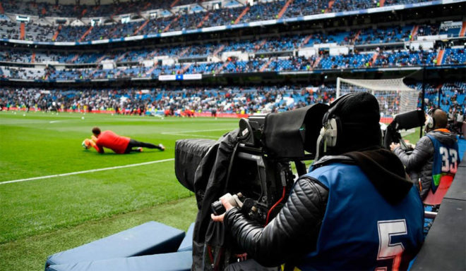 A TV crew member films the warm-up session ahead of the Spanish league football match between Real Madrid CF and Club Atletico de Madrid at the Santiago Bernabeu stadium in Madrid on April 8, 2018. / AFP PHOTO / GABRIEL BOUYS (Photo credit should read GABRIEL BOUYS/AFP/Getty Images)