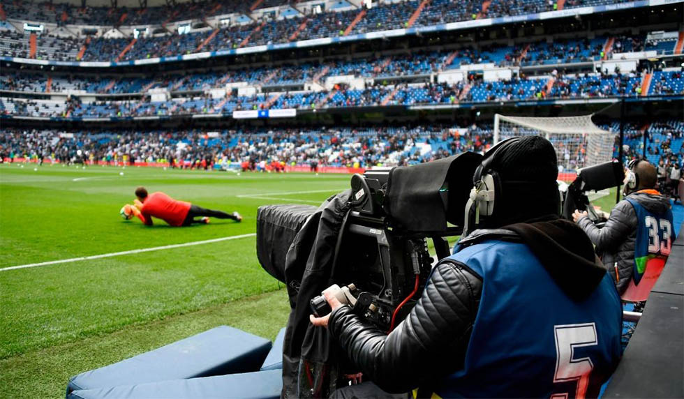 A TV crew member films the warm-up session ahead of the Spanish league football match between Real Madrid CF and Club Atletico de Madrid at the Santiago Bernabeu stadium in Madrid on April 8, 2018. / AFP PHOTO / GABRIEL BOUYS (Photo credit should read GABRIEL BOUYS/AFP/Getty Images)