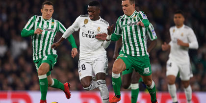 SEVILLE, SPAIN - JANUARY 13: Vinicius Jr of Real Madrid CF (C) being followed by Andres Guardado of Real Betis Balompie (L) and Giovani Lo Celso of Real Betis Balompie (R) during the La Liga match between Real Betis Balompie and Real Madrid CF at Estadio Benito Villamarin on January 13, 2019 in Seville, Spain. (Photo by Aitor Alcalde/Getty Images)