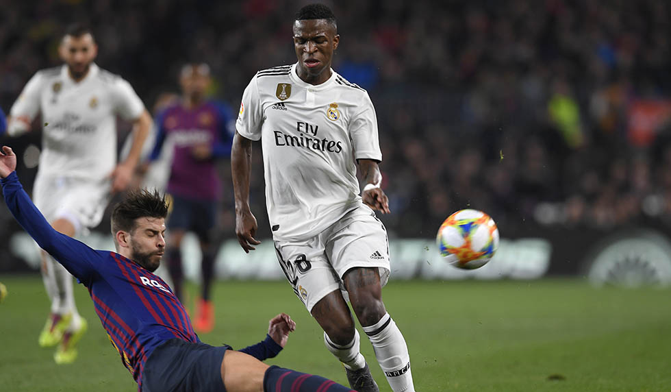 Barcelona's Spanish defender Gerard Pique (L) vies for the ball with Real Madrid's Brazilian forward Vinicius Junior during the Spanish Copa del Rey (King's Cup) semi-final first leg football match between FC Barcelona and Real Madrid CF at the Camp Nou stadium in Barcelona on February 6, 2019. (Photo by LLUIS GENE / AFP) (Photo credit should read LLUIS GENE/AFP/Getty Images)