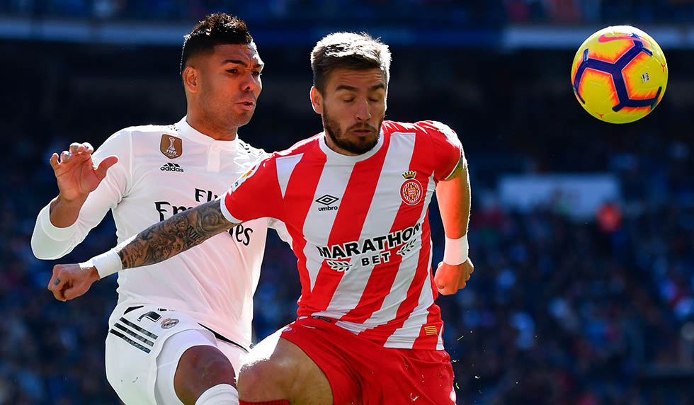 Real Madrid's Brazilian midfielder Casemiro challenges Girona's Spanish midfielder Portu (R) during the Spanish League football match between Real Madrid and Girona at the Santiago Bernabeu stadium in Madrid on February 17, 2019. (Photo by GABRIEL BOUYS / AFP) (Photo credit should read GABRIEL BOUYS/AFP/Getty Images)