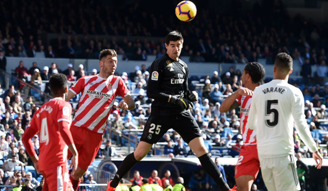 MADRID, SPAIN - FEBRUARY 17: Thibaut Courtois of Real Madrid headers the ball over Pedro Alcala of Girona during the La Liga match between Real Madrid CF and Girona FC at Estadio Santiago Bernabeu on February 17, 2019 in Madrid, Spain. (Photo by Denis Doyle/Getty Images)