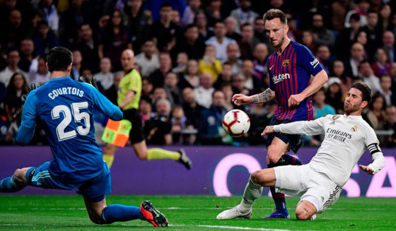 Barcelona's Croatian midfielder Ivan Rakitic (C) scores a goal past Real Madrid's Spanish defender Sergio Ramos (R) and Real Madrid's Belgian goalkeeper Thibaut Courtois (L) during the Spanish league football match between Real Madrid CF and FC Barcelona at the Santiago Bernabeu stadium in Madrid on March 2, 2019. (Photo by JAVIER SORIANO / AFP) (Photo credit should read JAVIER SORIANO/AFP/Getty Images)