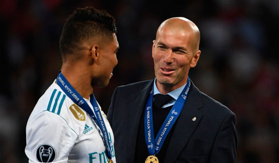 Real Madrid's Brazilian midfielder Casemiro speaks with Real Madrid's French coach Zinedine Zidane (R) as Real Madrid players celebrate winning the UEFA Champions League final football match between Liverpool and Real Madrid at the Olympic Stadium in Kiev, Ukraine on May 26, 2018. - Real Madrid defeated Liverpool 3-1. (Photo by Paul ELLIS / AFP) (Photo credit should read PAUL ELLIS/AFP/Getty Images)