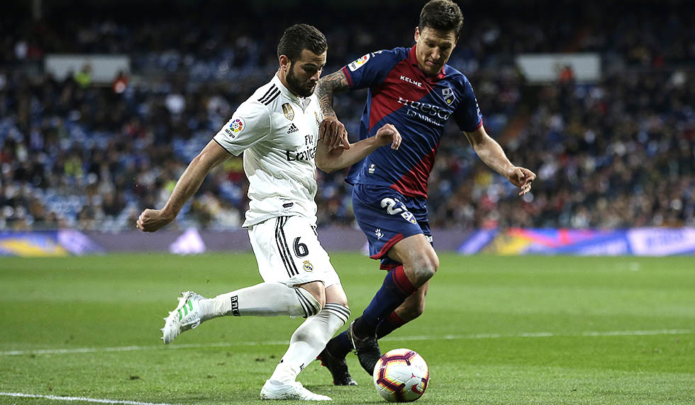 MADRID, SPAIN - MARCH 31: Nacho of Real Madrid goes past Damian Musto of Huesca during the La Liga match between Real Madrid CF and SD Huesca at Estadio Santiago Bernabeu on March 31, 2019 in Madrid, Spain. (Photo by Gonzalo Arroyo Moreno/Getty Images)