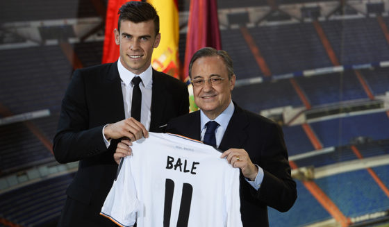 New Welsh striker Gareth Bale of Real Madrid (L) poses with his new jersey next to Real Madrid's President Florentino Perez during his presentation at the Santiago Bernabeu stadium in Madrid on September 2, 2013. Bale was unveiled as a Real Madrid player today after his prolonged transfer from Tottenham Hotspur was finally completed for an unconfirmed world record fee late September 1. The Welshman has agreed a six-year deal believed to be worth 10 million euros net a year and will be presented to the media and the club's fans after undergoing a medical in the Spanish capital. AFP PHOTO/ PIERRE-PHILIPPE MARCOU (Photo credit should read PIERRE-PHILIPPE MARCOU/AFP/Getty Images)