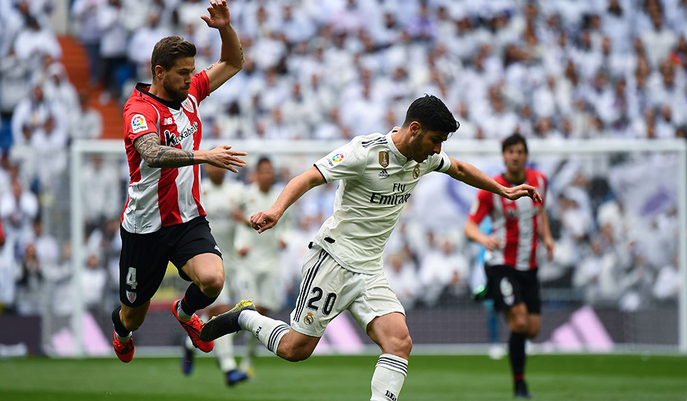 Real Madrid's Spanish midfielder Marco Asensio (R) challenges Athletic Bilbao's Spanish defender Inigo Martinez during the Spanish League football match between Real Madrid and Athletic Bilbao at the Santiago Bernabeu Stadium in Madrid on April 21, 2019. (Photo by GABRIEL BOUYS / AFP) (Photo credit should read GABRIEL BOUYS/AFP/Getty Images)