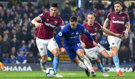 Chelsea's Belgian midfielder Eden Hazard (C) runs past West Ham United's Paraguayan defender Fabián Balbuena (L) and West Ham United's English midfielder Mark Noble (2nd R) during the English Premier League football match between Chelsea and West Ham United at Stamford Bridge in London on April 8, 2019. (Photo by OLLY GREENWOOD / AFP) / RESTRICTED TO EDITORIAL USE. No use with unauthorized audio, video, data, fixture lists, club/league logos or 'live' services. Online in-match use limited to 120 images. An additional 40 images may be used in extra time. No video emulation. Social media in-match use limited to 120 images. An additional 40 images may be used in extra time. No use in betting publications, games or single club/league/player publications. / (Photo credit should read OLLY GREENWOOD/AFP/Getty Images)