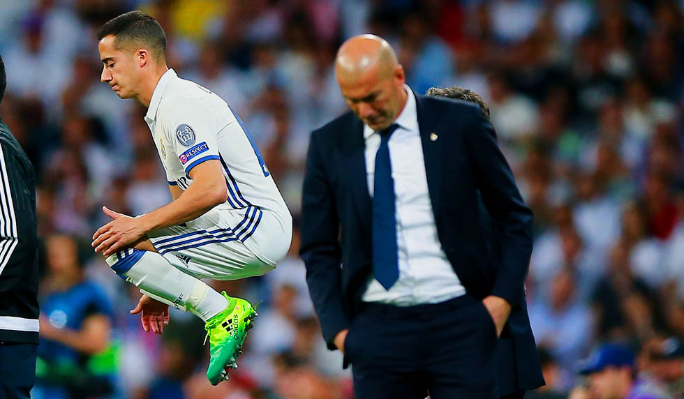 MADRID, SPAIN - APRIL 18: Lucas Vazquez (L) of Real Madrid CF warms up behind his coach Zinedine Zidane (R) during the UEFA Champions League Quarter Final second leg match between Real Madrid CF and FC Bayern Muenchen at Estadio Santiago Bernabeu on April 18, 2017 in Madrid, Spain. (Photo by Gonzalo Arroyo Moreno/Getty Images)