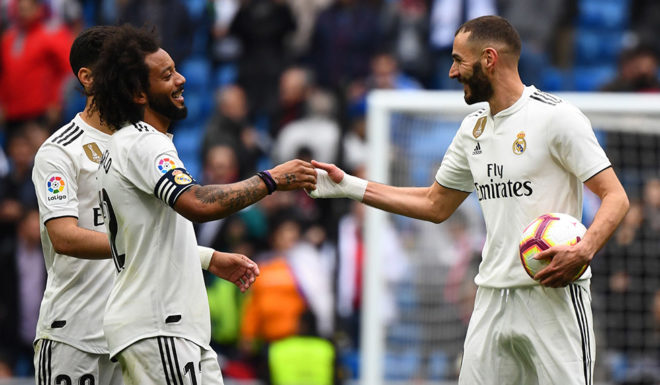 Real Madrid's French forward Karim Benzema (R) celebrates with Real Madrid's Brazilian defender Marcelo and Real Madrid's Spanish midfielder Marco Asensio (L) at the end of the Spanish League football match between Real Madrid and Athletic Bilbao at the Santiago Bernabeu Stadium in Madrid on April 21, 2019. (Photo by GABRIEL BOUYS / AFP) (Photo credit should read GABRIEL BOUYS/AFP/Getty Images)