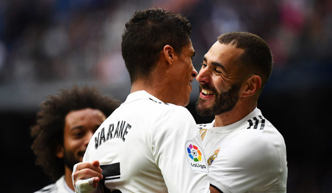 Real Madrid's French forward Karim Benzema (R) celebrates with Real Madrid's French defender Raphael Varane after scoring a second goal during the Spanish League football match between Real Madrid and Athletic Bilbao at the Santiago Bernabeu Stadium in Madrid on April 21, 2019. (Photo by GABRIEL BOUYS / AFP) (Photo credit should read GABRIEL BOUYS/AFP/Getty Images)