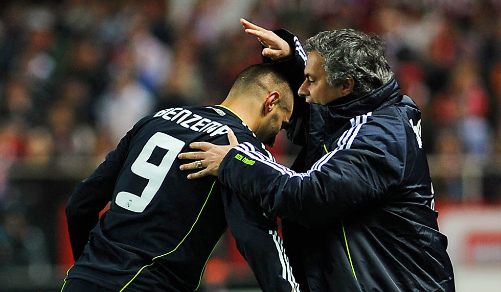 Real Madrid's French forward Karim Benzema (L) celebrates with Real Madrid's Portuguese coach Jose Mourinho after scoring during the Spanish King's Cup (Copa del Rey) semifinal first leg football match Sevilla FC vs Real Madrid on January 26, 2011 at the Ramon Sanchez Pizjuan stadium in Sevilla. AFP PHOTO/ CRISTINA QUICLER (Photo credit should read CRISTINA QUICLER/AFP/Getty Images)