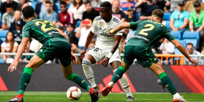 Real Madrid's Brazilian forward Vinicius Junior (C) challenges Real Betis' Algerian defender Aissa Mandi (L) and Real Betis' Spanish defender Francis during the Spanish League football match between Real Madrid and Real Betis at the Santiago Bernabeu stadium in Madrid on May 19, 2019. (Photo by PIERRE-PHILIPPE MARCOU / AFP) (Photo credit should read PIERRE-PHILIPPE MARCOU/AFP/Getty Images)
