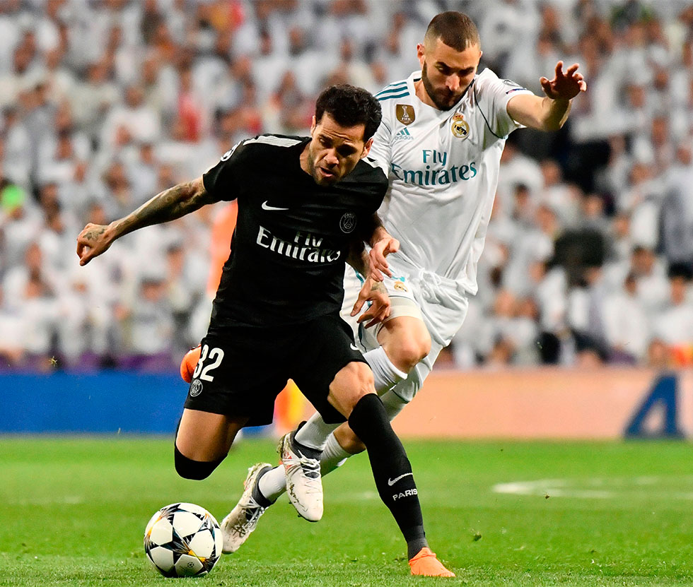 Paris Saint-Germain's Brazilian defender Dani Alves (L) vies with Real Madrid's French forward Karim Benzema (R) during the UEFA Champions League round of sixteen first leg football match Real Madrid CF against Paris Saint-Germain (PSG) at the Santiago Bernabeu stadium in Madrid on February 14, 2018. / AFP PHOTO / CHRISTOPHE SIMON (Photo credit should read CHRISTOPHE SIMON/AFP/Getty Images)
