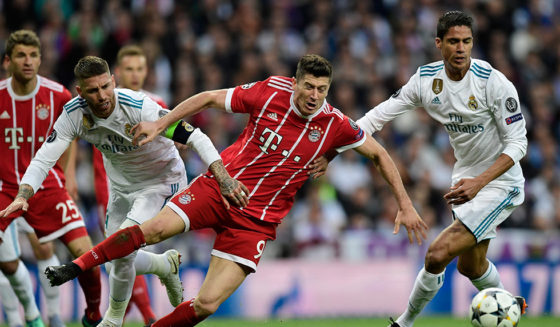 Bayern Munich's Polish forward Robert Lewandowski (C) vies with Real Madrid's Spanish defender Sergio Ramos (L) and Real Madrid's French defender Raphael Varane during the UEFA Champions League semi-final second leg football match between Real Madrid and Bayern Munich at the Santiago Bernabeu Stadium in Madrid on May 1, 2018. (Photo by JAVIER SORIANO / AFP) (Photo credit should read JAVIER SORIANO/AFP/Getty Images)